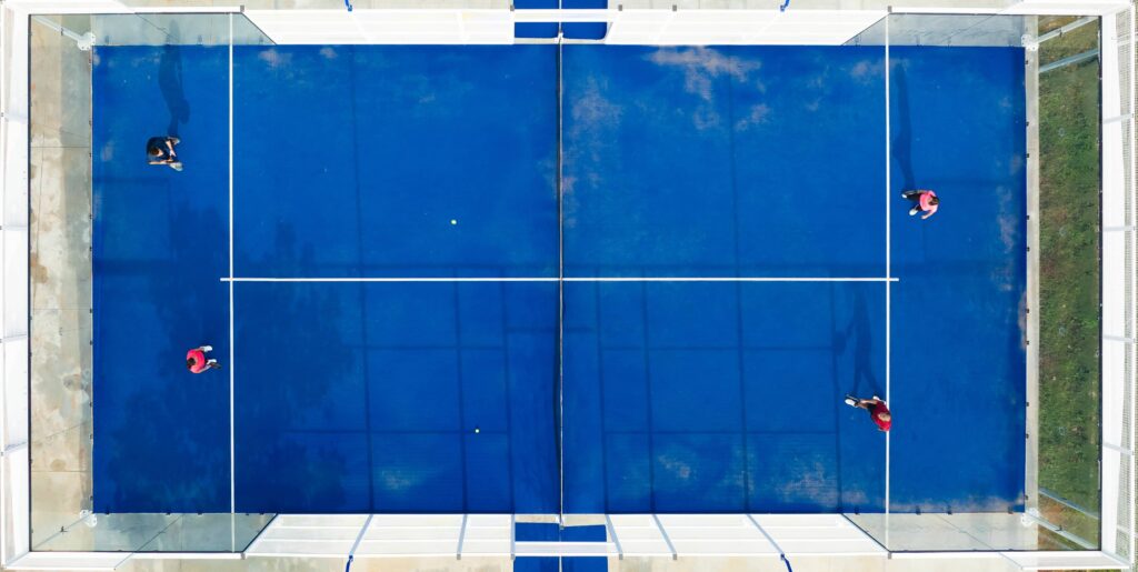 Aerial view of a blue padel court with players