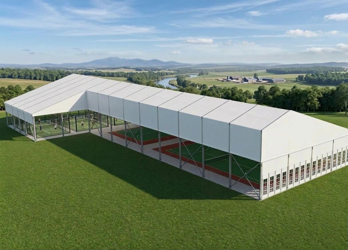 Padel and multi-sport courts under an L-shaped gable canopy structure in open countryside
