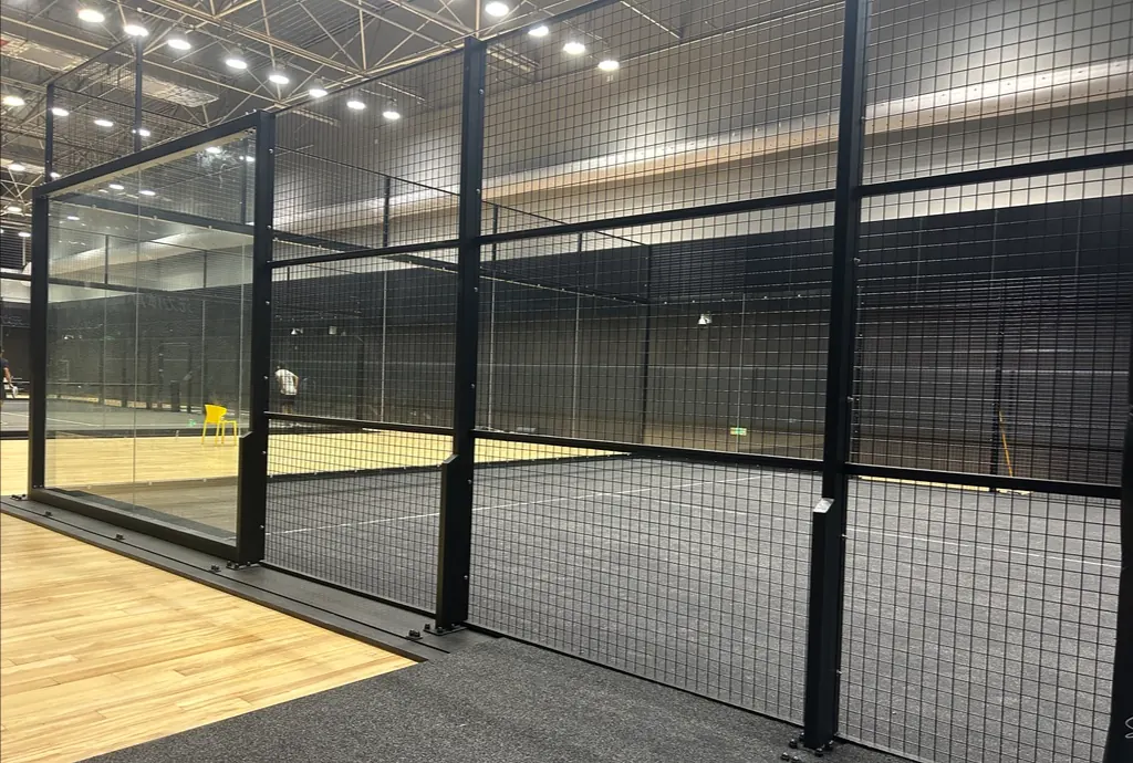 Dream Courts club padel court: black steel frame, tempered glass corner and wire mesh sides under LED lighting